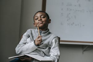 Thoughtful black boy with pencil